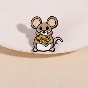 Détail d'un pin's en émail en forme de souris brune tenant du fromage avec finition lisse