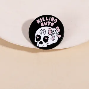 Gros plan d'un pin's Killing & Cute montrant un crâne avec des yeux en cœur rose