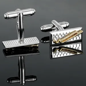 Detailed close-up of luxury silver cufflinks with golden hockey stick motif on dark surface