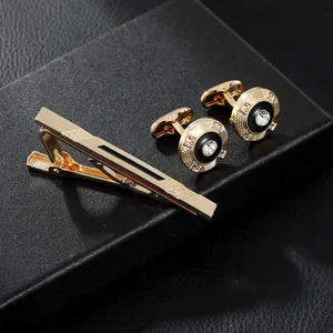 Macro shot of gold-plated tie clip and cufflinks set with black enamel and zircons