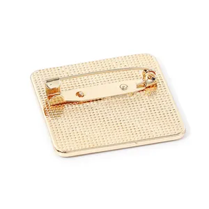 Vintage gold car brooch back view showing safety pin and textured metal finish