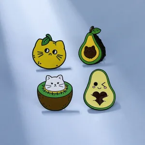 Detail view of four creative cartoon cat enamel pins featuring fruit themes on blue surface