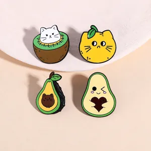 Detailed view of four colorful enamel cat and fruit badges on a decorative pedestal
