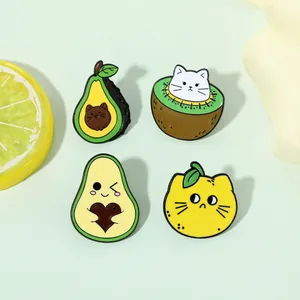 Detailed view of four enamel pins featuring cute black cats combined with fruits like avocado