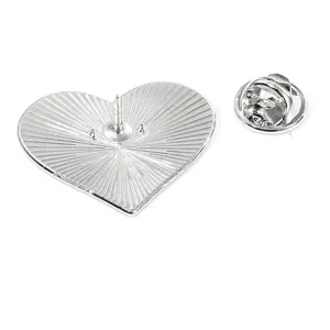 Silver heart-shaped metal brooch back with butterfly pin clutch on white background