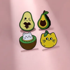 Detailed close-up of four creative cartoon enamel pins featuring fruit and cat designs