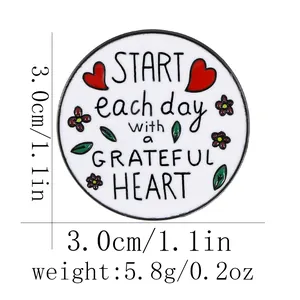 Pin's rond en émail avec motif floral de cœur et citation inspirante sur fond blanc