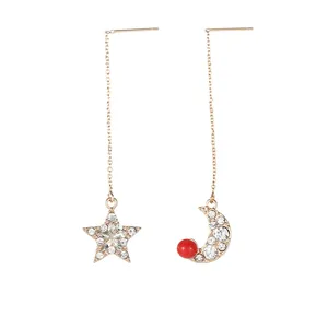 Asymmetric gold star and moon tassel earrings with crystal pave and red bead details