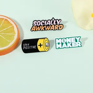 Close-up of enamel pins featuring Socially Awkward and Stay Positive battery designs