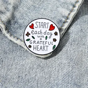 Badge rond en émail avec citation inspirante Start each day with a grateful heart sur denim