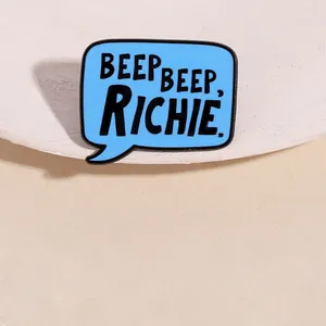 Detailed view of blue enamel bubble brooch with Beep Beep Richie text engraving