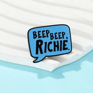 Macro detail of sky blue enamel pin with Beep Beep Richie quote on a display stand