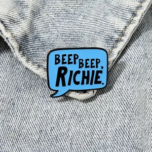 Blue dialogue bubble enamel pin with Beep Beep Richie text on denim background