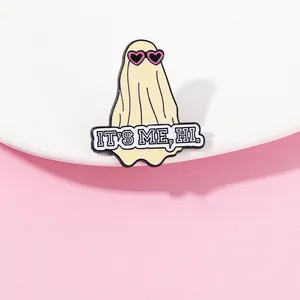 Detailed shot of ghost enamel pin with heart glasses and It's Me Hi banner design