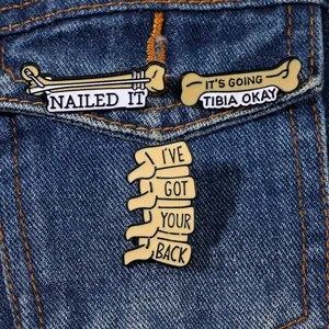 Trois pin's en émail sur le thème médical avec des jeux de mots sur une veste en jean