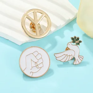 Detailed view of enamel peace dove brooches with olive branch and peace symbols