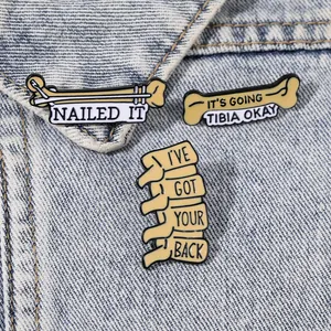 Trois broches médicales créatives en émail avec jeux de mots sur fond de denim