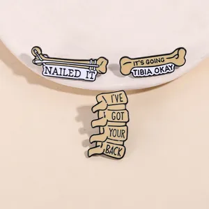 Détail de trois broches en émail médical avec anatomie squelettique et jeux de mots