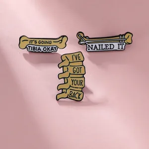 Vue détaillée de trois broches en émail médical avec jeux de mots sur fond rose doux