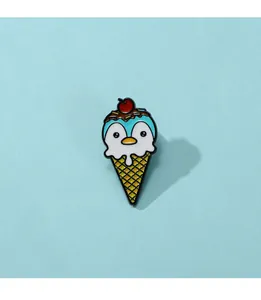 Detail einer Pinguin-Eiscreme-Emaille-Anstecknadel mit Kirsche obenauf und blauem Grund