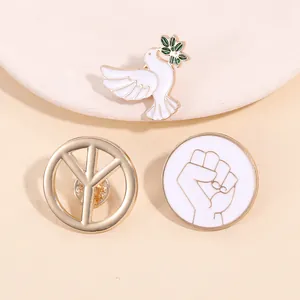 Close-up of enamel peace dove, symbol, and unity fist badges on a ceramic plate