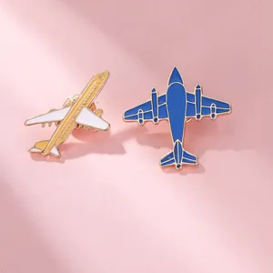 Vue détaillée de deux mini pins d'avion en émail blanc et bleu marine avec placage d'or