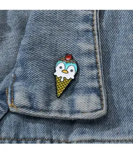 Nahaufnahme einer süßen Emaille-Brosche Pinguin Eiscreme auf einem Denim-Kragen