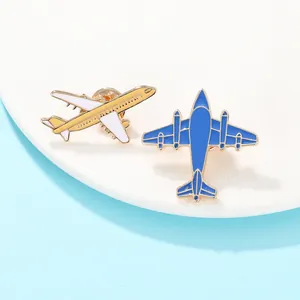Vue macro de deux mini broches d'avion en émail jaune et bleu avec une bordure dorée