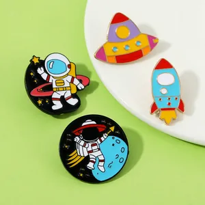Detailed view of 4-piece astronaut enamel pin set with UFO, rocket, and planet designs