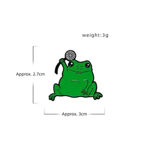 Broche en émail grenouille verte avec pissenlit, poids 3g et dimensions 2,7x3cm sur blanc