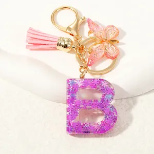 Portachiavi lettera B in resina viola con paillettes, farfalla e nappa rosa