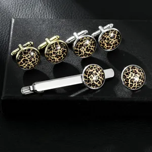 Dettaglio macro del set di accessori da uomo con gemelli e fermacravatta leopardati
