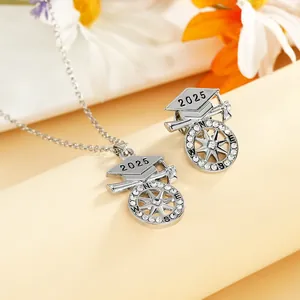 Detail of 2025 graduation cap necklace and brooch set with compass design and crystals