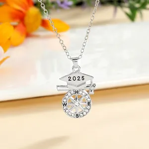Macro shot of 2025 graduation necklace featuring a cap, compass, and sparkling crystals