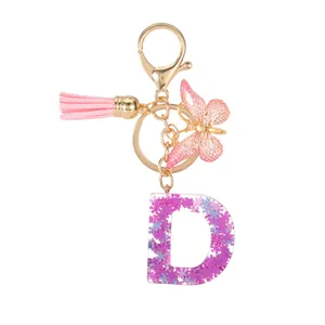 Portachiavi lettera D in resina viola con farfalla rosa e paillettes a forma di fiore