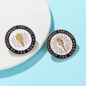 Detail of blue enamel Outstanding Employee of the Month badges with gold torch emblem