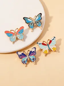Vue détaillée de quatre broches papillon en émail coloré aux contours métalliques dorés