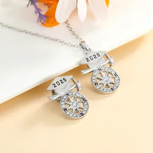 Detail of 2025 graduation cap necklace and compass pin with sparkling rhinestones