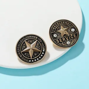 Macro shot of two vintage gold badges with 3D stars and Excellent Service engraving