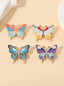 Vue détaillée de quatre broches papillon colorées en émail avec alliage doré