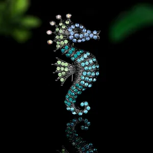 Macro shot of seahorse brooch with multicolored rhinestones on a black metal base
