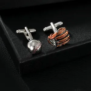Macro detail of silver baseball and bronze glove cufflinks on black leather background