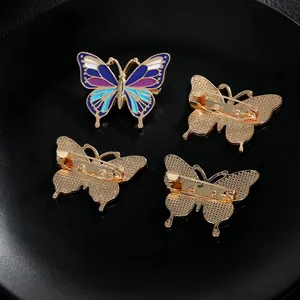 Détail de broches papillon en émail montrant le devant coloré et le dos doré à texture alvéolée