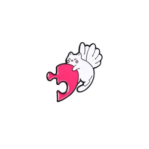 Cartoon winged cat enamel pin with pink puzzle piece for clothing and bags
