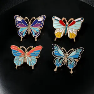 Lot de quatre broches papillon colorées en émail avec détails en métal doré