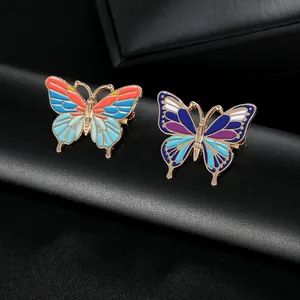 Vue macro de broches papillon en émail coloré avec détails dorés sur cuir noir