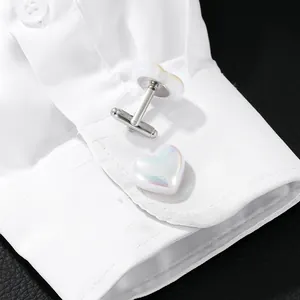 Boutons de manchette cœur irrégulier avec nacre sur le poignet d'une chemise blanche