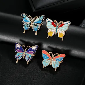 Détail de quatre broches papillon en émail coloré avec placage or sur fond de cuir noir