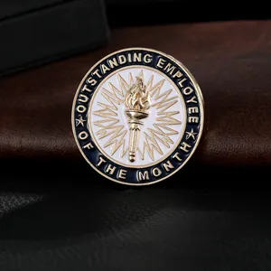 Macro detail of gold Outstanding Employee of the Month metal pin with enamel torch design