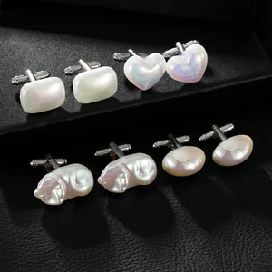 Détail de quatre paires de boutons de manchette en perles élégantes sur un support noir